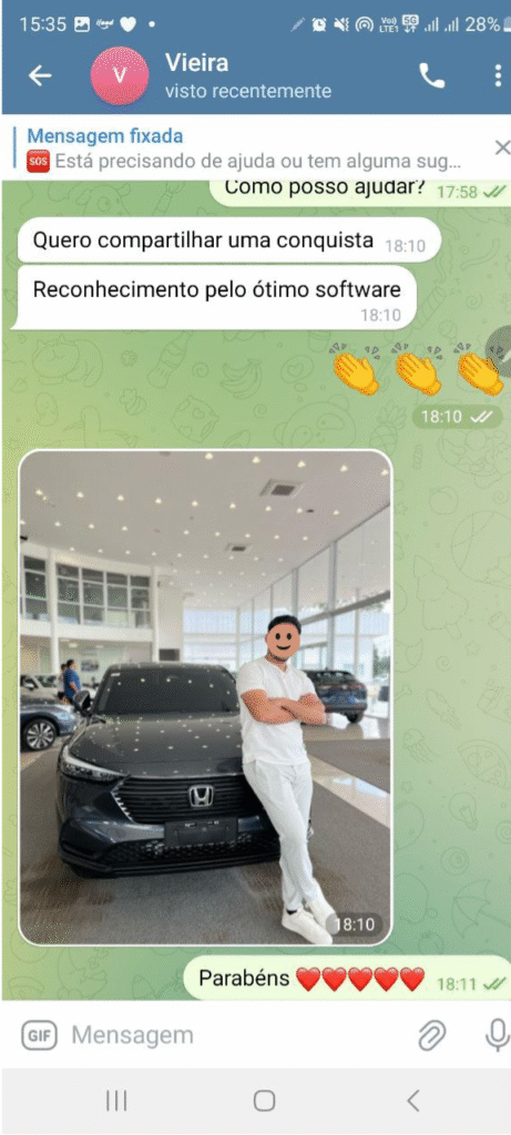 Homem sorridente em pé ao lado de um carro Honda em uma concessionária, comemorando uma conquista e recebendo reconhecimento pelo uso de um excelente software.